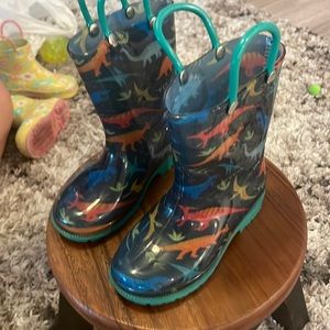 Kids size 8 rain boots with dinosaurs on it.